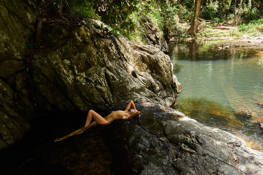 KaneSkennar-Woman lying on waterfall in nature