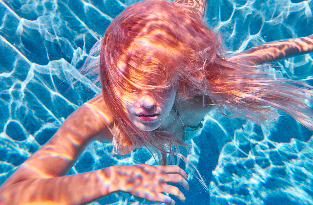 KaneSkennar-Girl underwater with pink hair swimming to camera