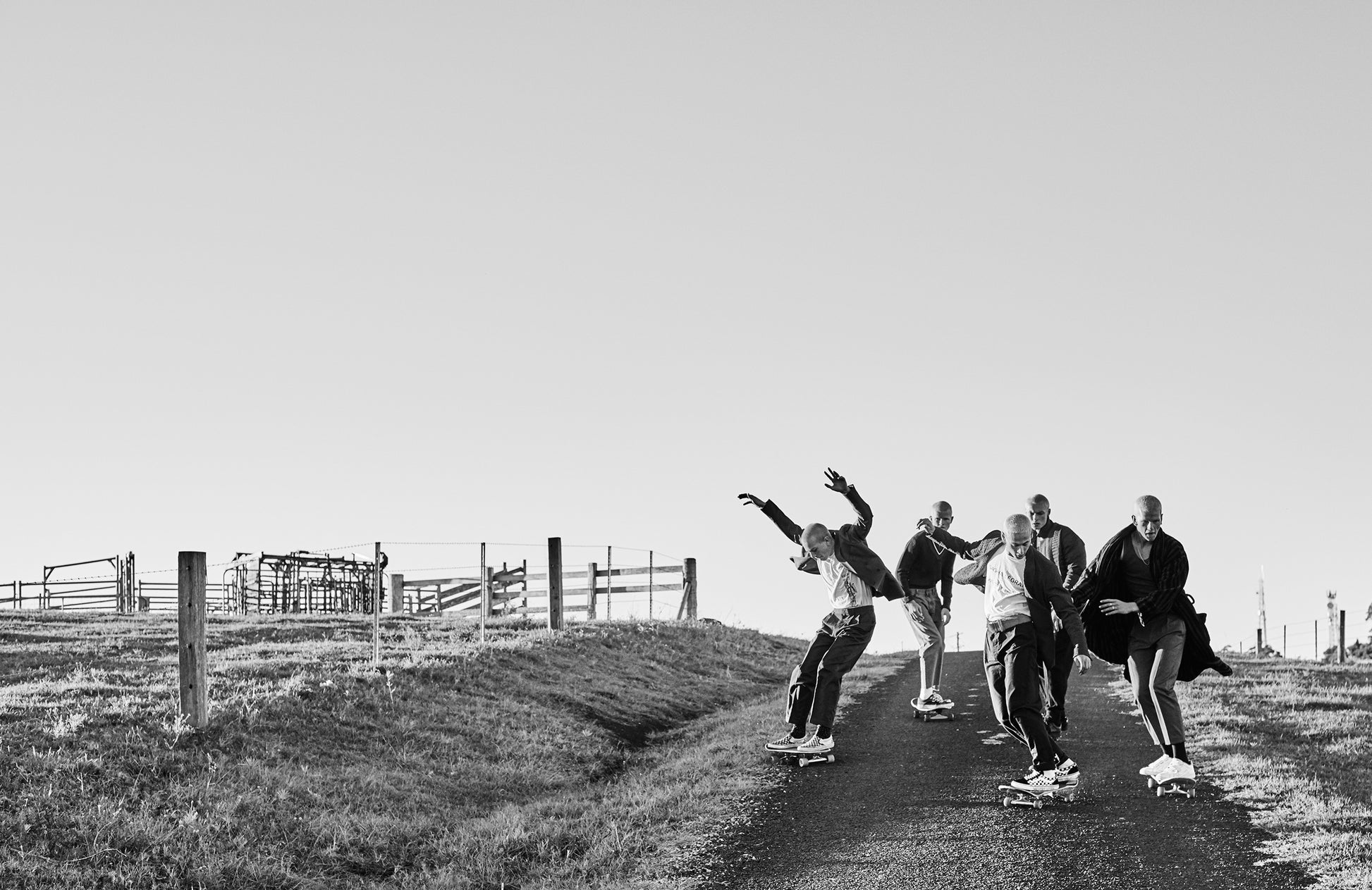 KaneSkennarphotographer-BW photo of shaved headed skaters,coming down the top of an old road.