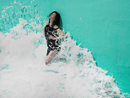 KaneSkennarphotographer-Wave splashing against wall with woman standing against it