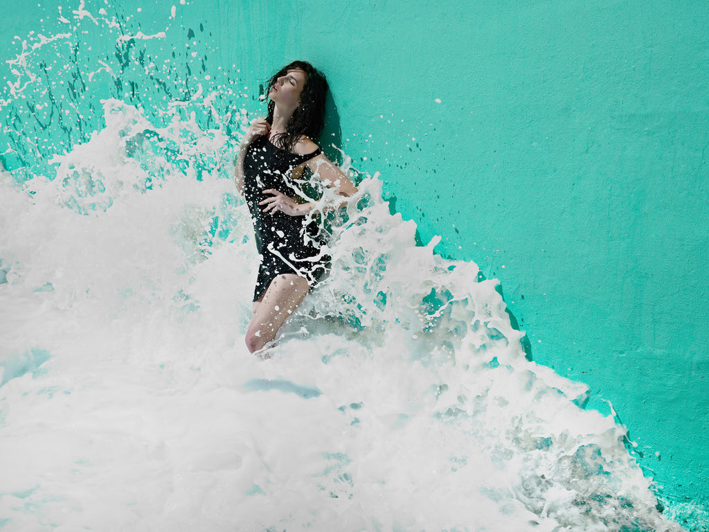 KaneSkennarphotographer-Wave splashing against wall with woman standing against it